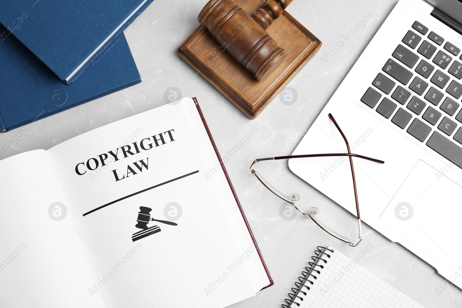 Photo of Flat lay composition with book, gavel and laptop on grey background. Copyright law concept