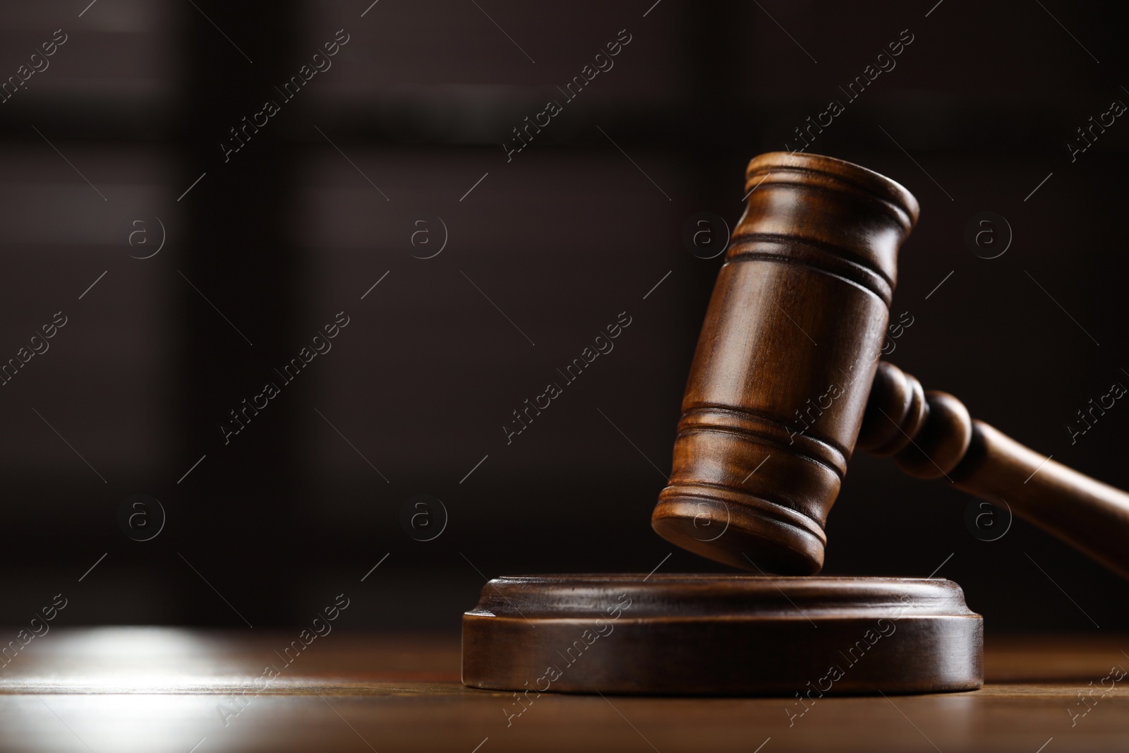 Photo of Wooden gavel on table against blurred background, closeup. Space for text