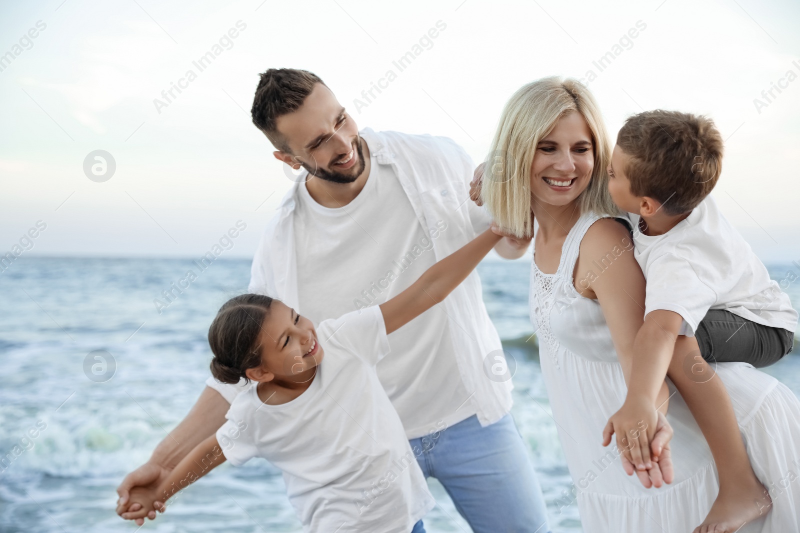 Photo of Happy family having fun on beach near sea