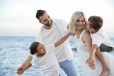 Happy family having fun on beach near sea