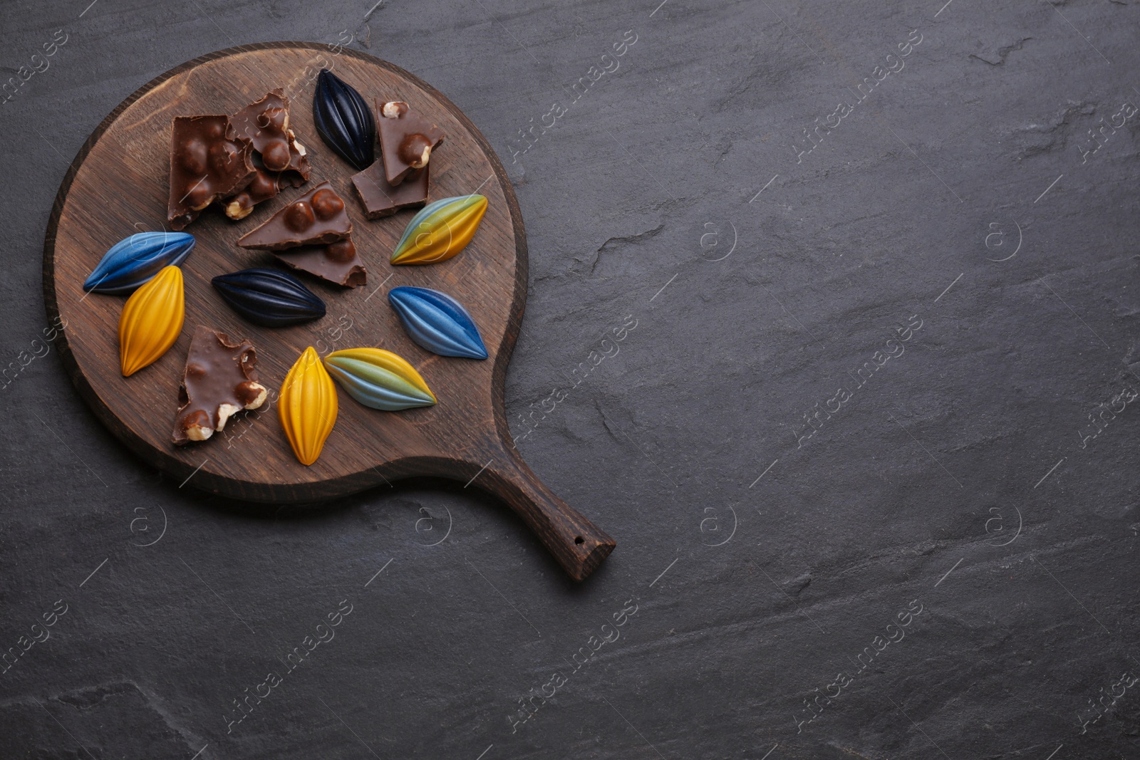 Photo of Tasty chocolate candies on black table, flat lay. Space for text