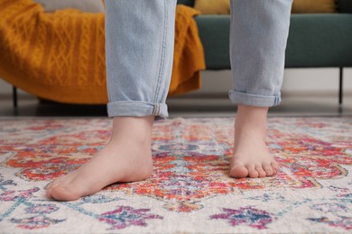 Photo of Woman standing on carpet with pattern in room, closeup