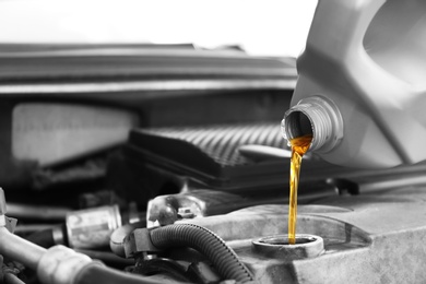 Pouring oil into car engine, closeup