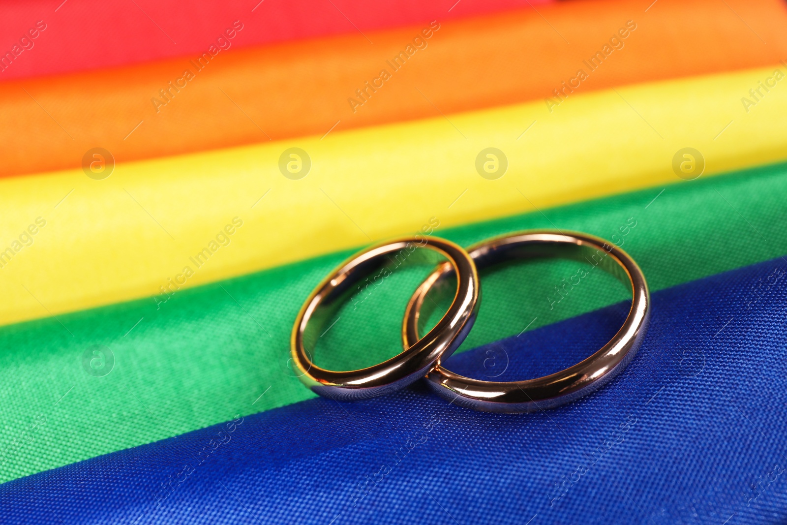 Photo of Wedding rings on rainbow LGBT flag, closeup