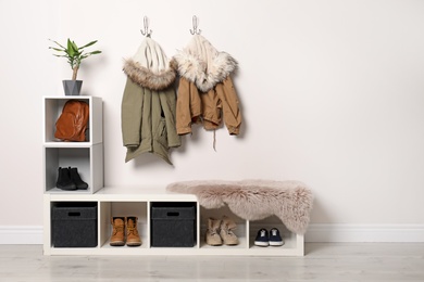 Photo of Modern hallway interior with hanging clothes and shoe rack