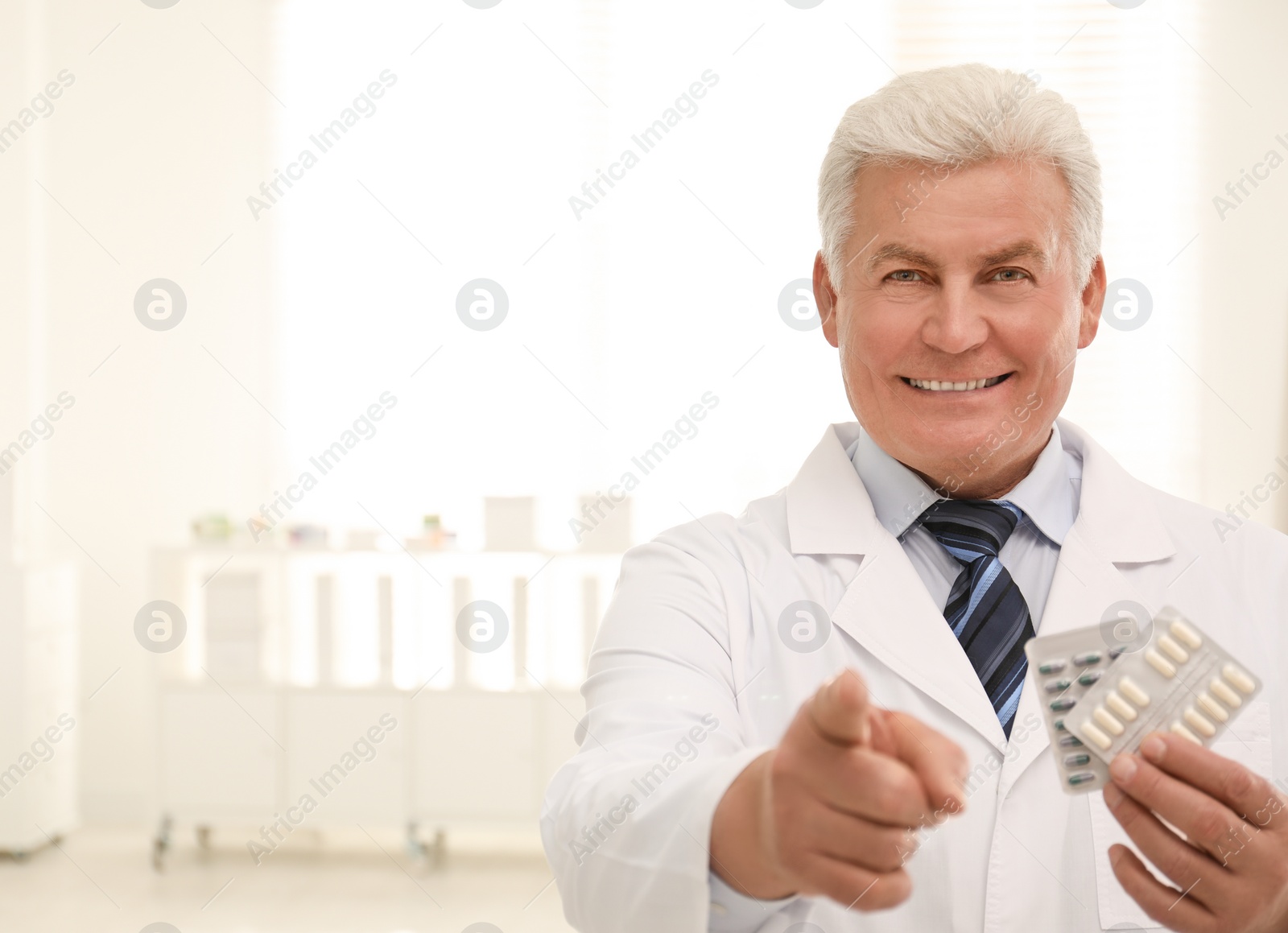 Photo of Senior pharmacist with pills in drugstore. Space for text