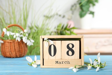 Photo of Greeting card for Women's Day. Beautiful snowdrops and wooden calendar on table