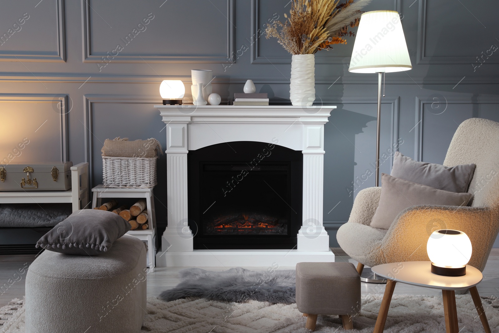 Photo of Beautiful fireplace, different decor and armchair in living room. Interior design