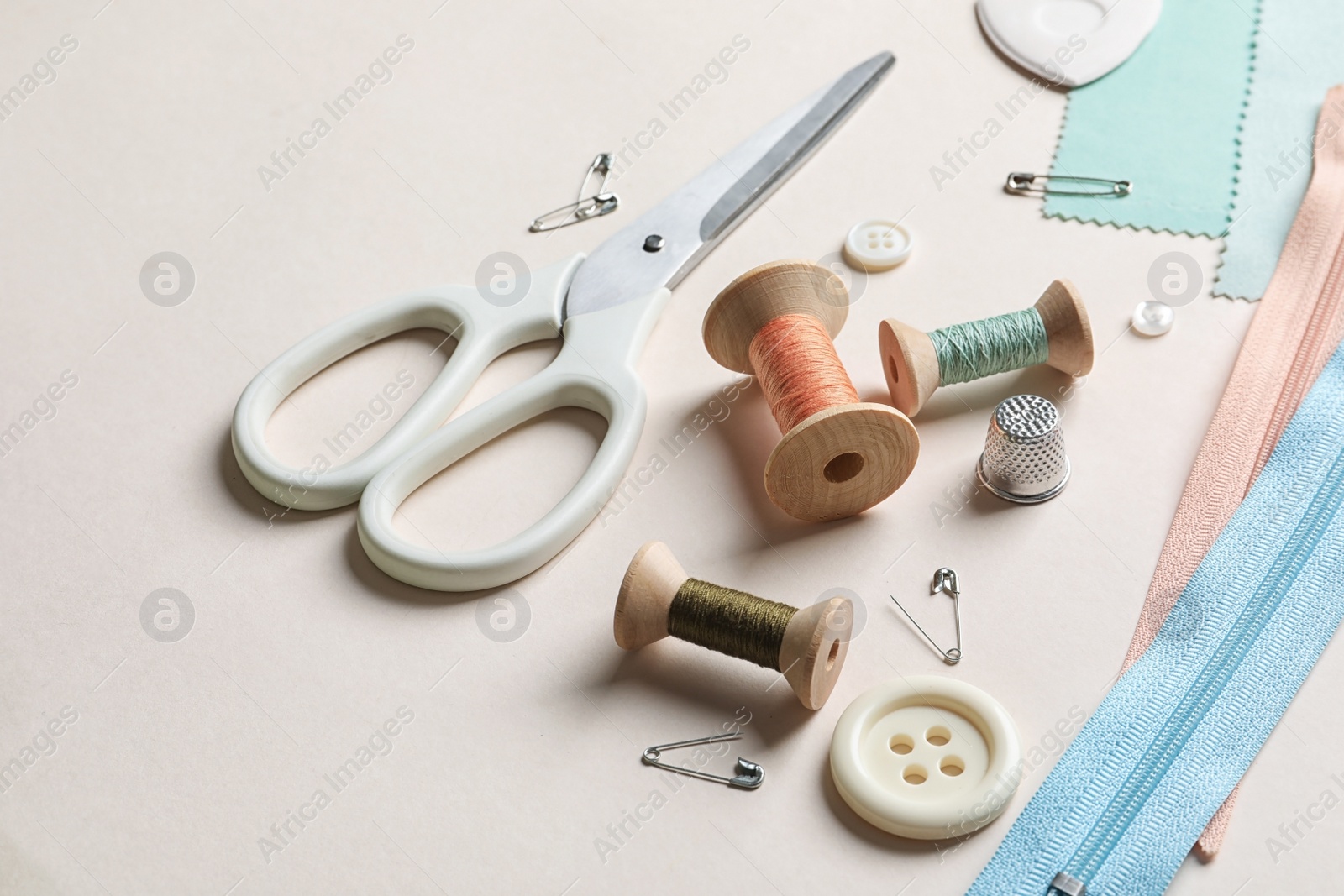 Photo of Set of tailoring accessories on light background