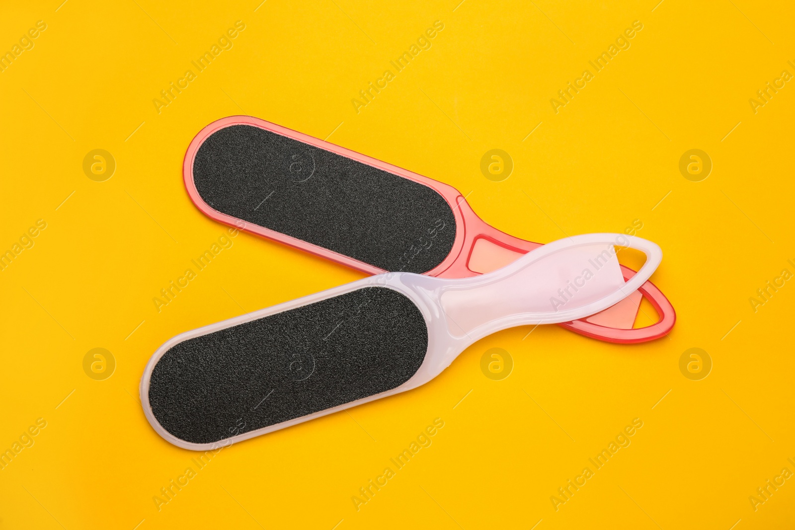Photo of Foot files on orange background, flat lay. Pedicure tools