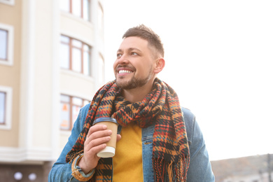 Photo of Man with cup of coffee on city street in morning