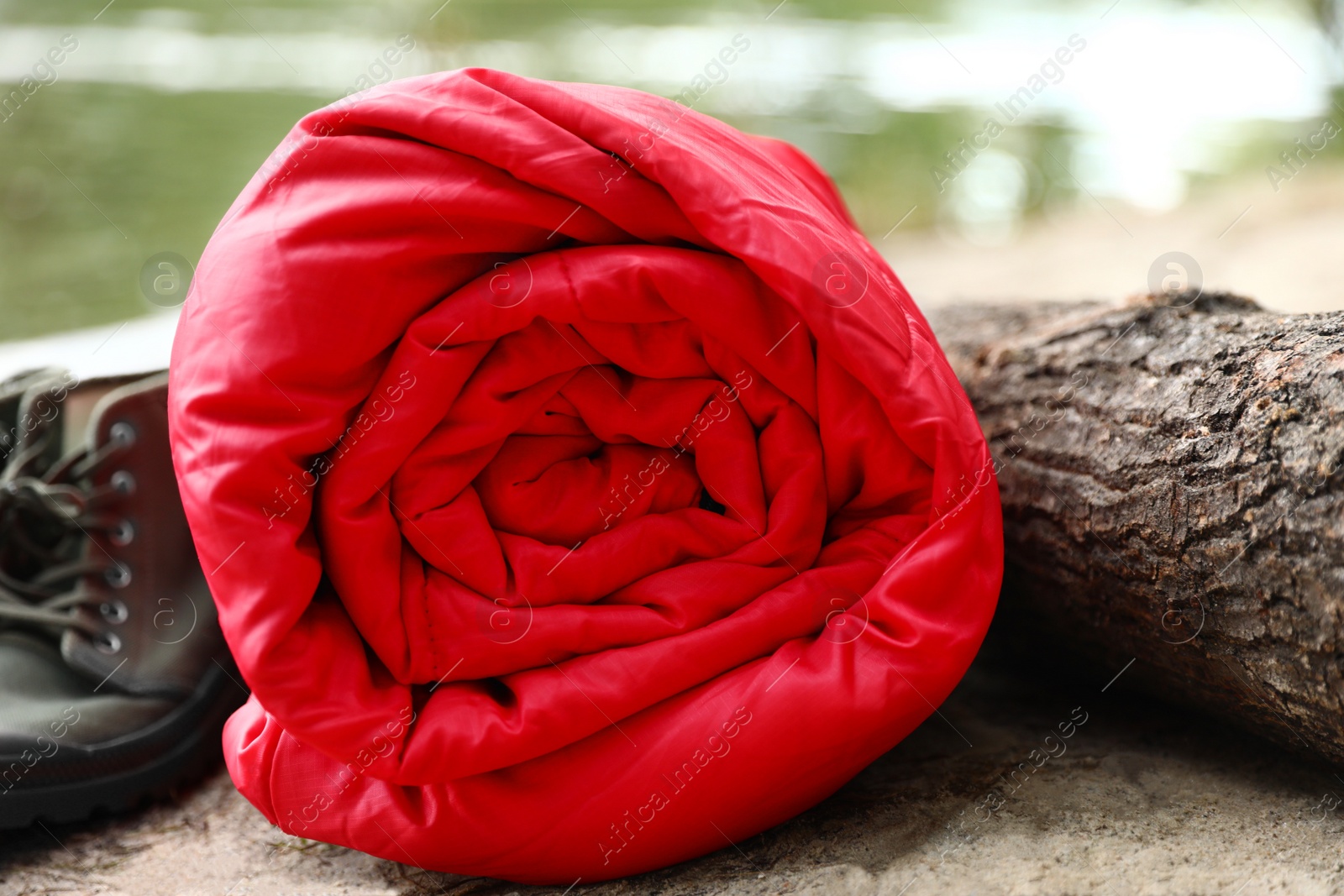 Photo of Rolled sleeping bag and boots on beach