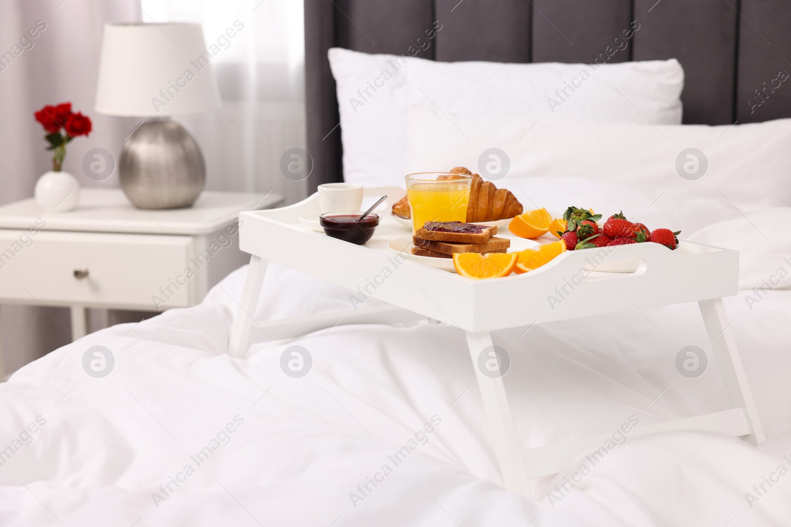 Tray with delicious breakfast on bed in room, closeup Photo of Tray with delicious breakfast on bed in room, closeup
