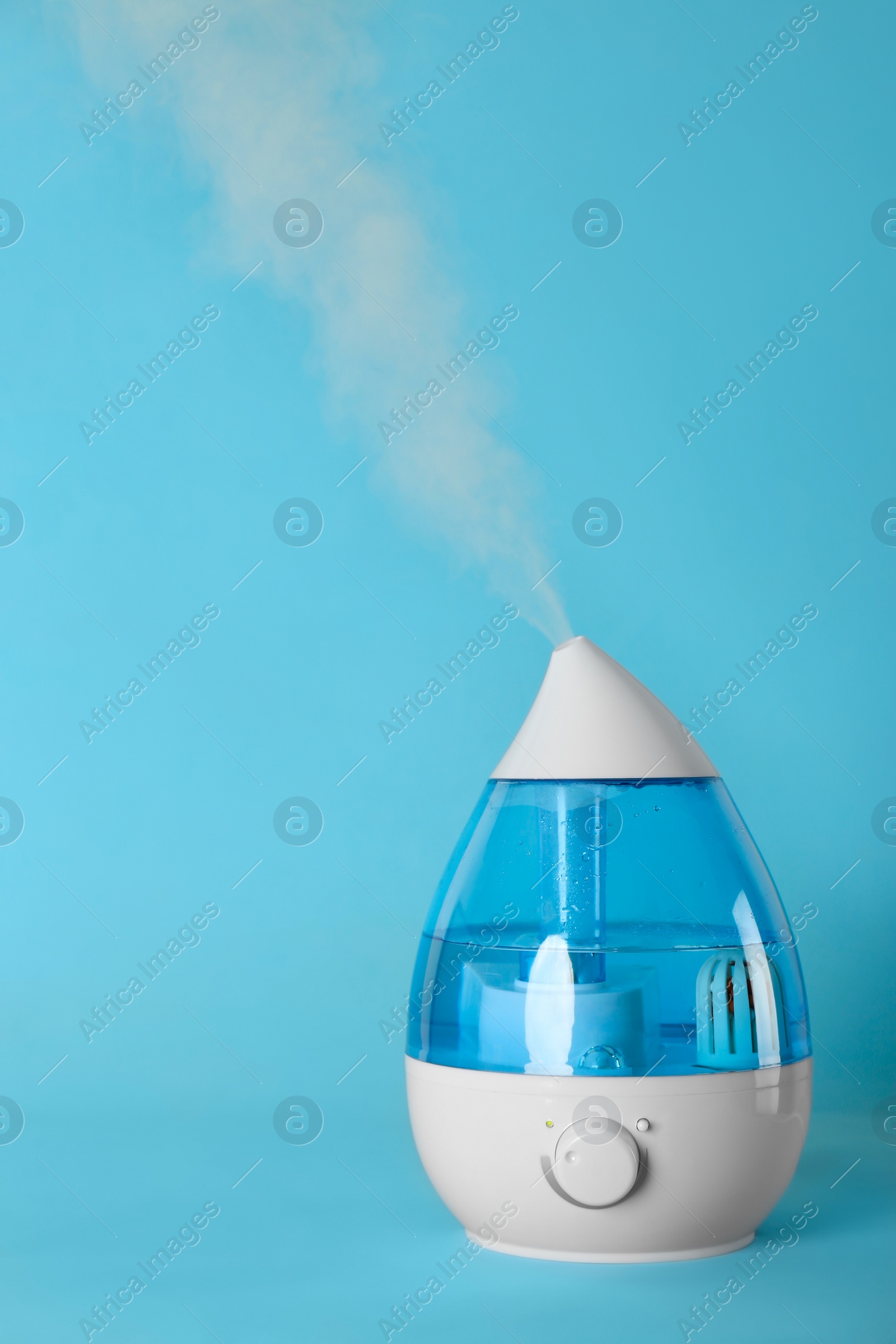 Photo of Modern air humidifier on light blue background