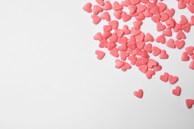 Photo of Pink heart shaped sprinkles on white background, top view