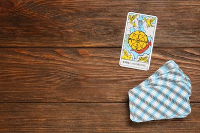 The Wheel of Fortune and other tarot cards on wooden table, flat lay. Space for text