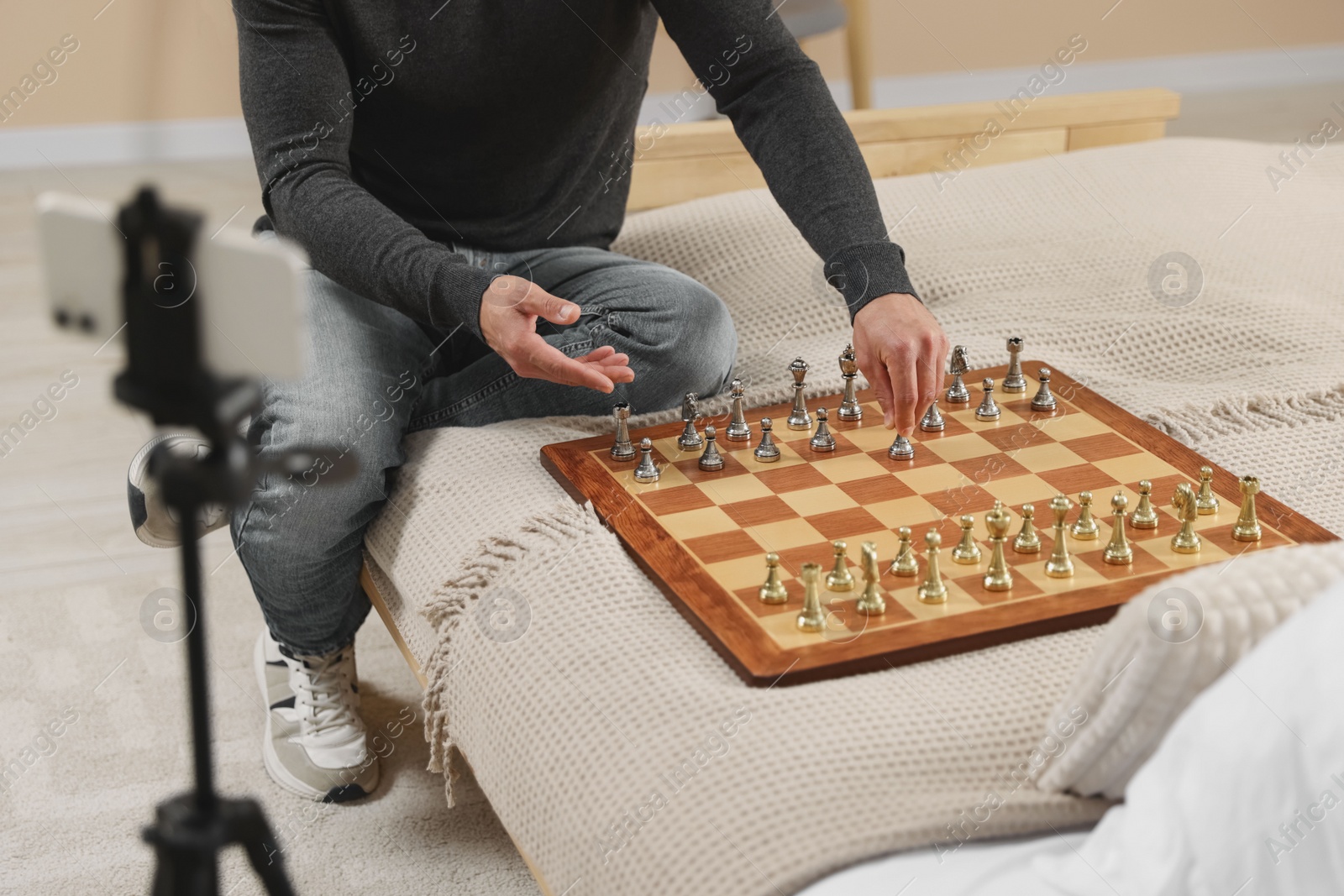 Photo of Teacher near chessboard conducting online lesson at home, closeup. Time for hobby