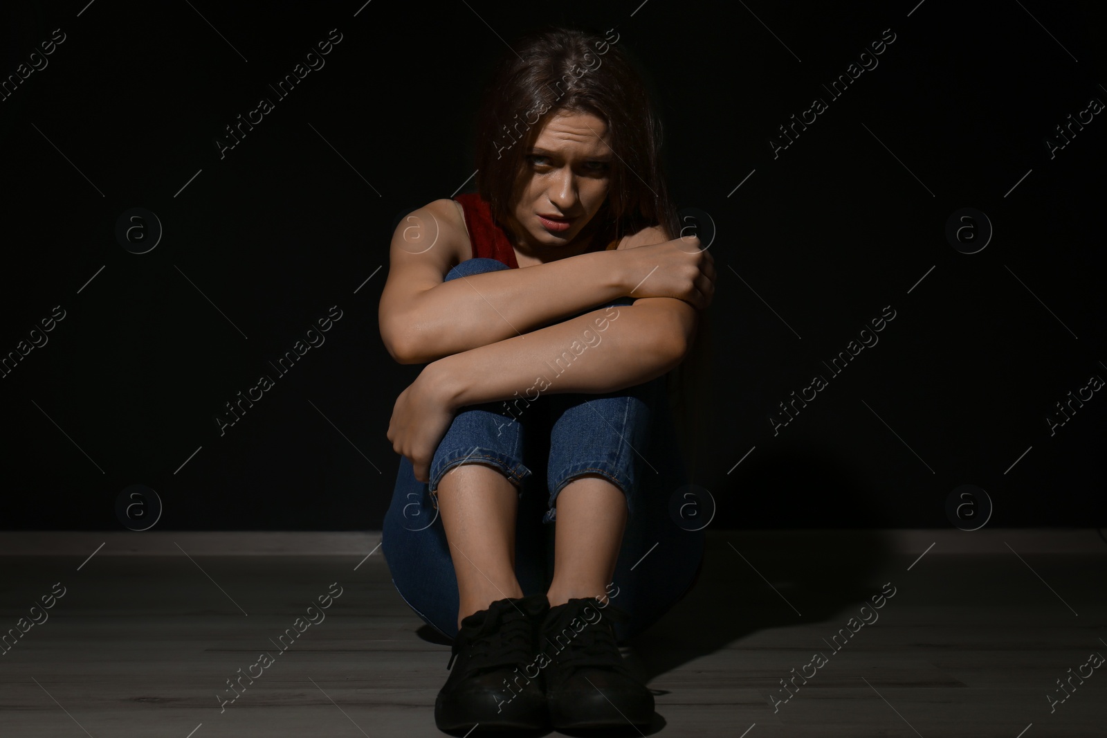 Photo of Abused young woman on black background. Domestic violence concept