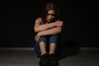 Photo of Abused young woman on black background. Domestic violence concept