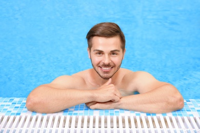 Photo of Handsome young man in swimming pool with refreshing water