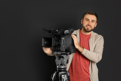 Photo of Operator with professional video camera on black background