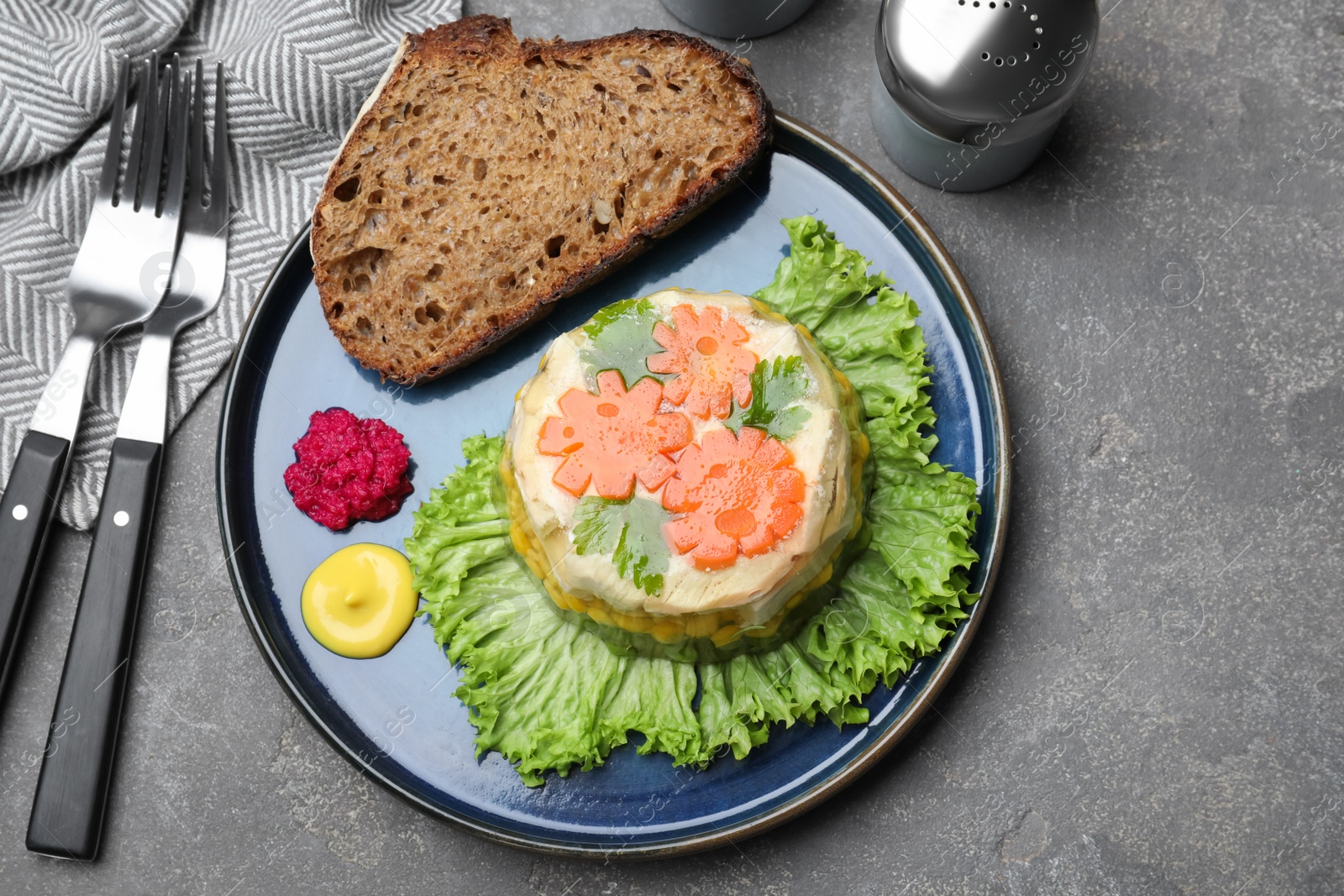 Photo of Delicious chicken aspic served on grey table, flat lay