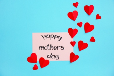 Photo of Greeting card with phrase "HAPPY MOTHER'S DAY" and paper hearts on color background