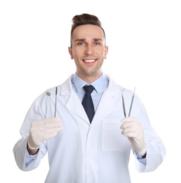 Photo of Male dentist holding professional tools on white background