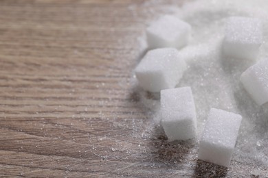 Photo of Different types of white sugar on wooden table, closeup. Space for text