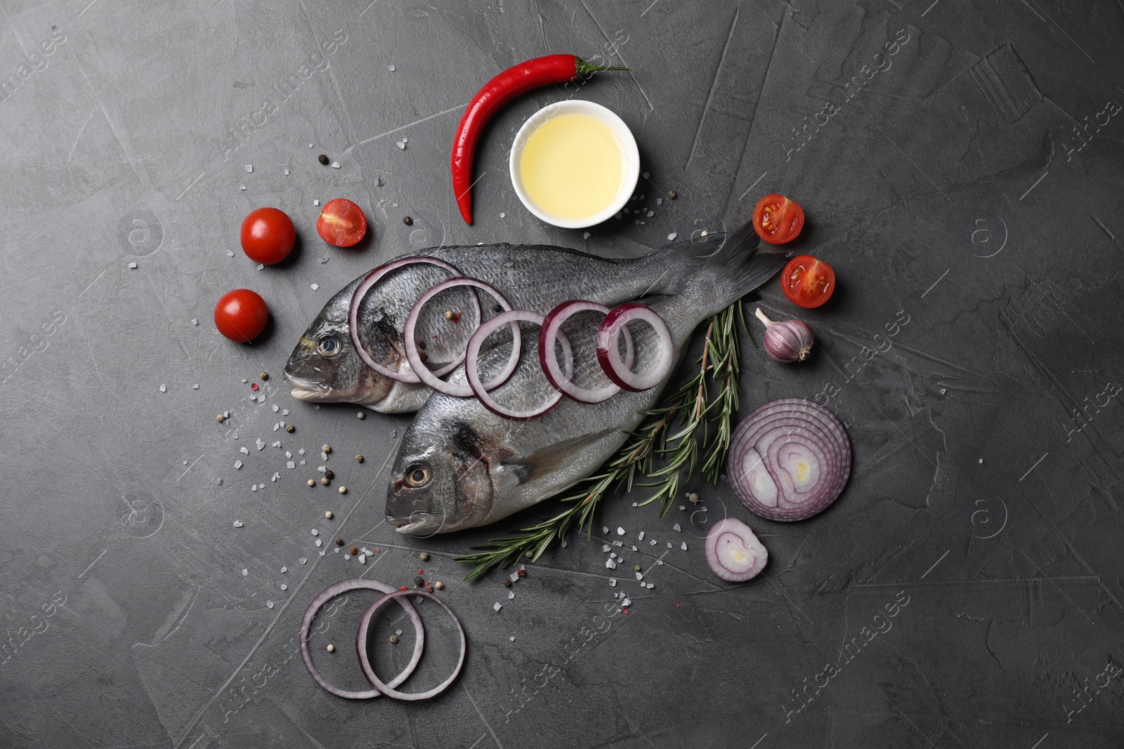 Photo of Fresh dorado fish and ingredients on grey table, flat lay