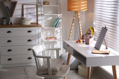 Photo of Stylish room interior with comfortable workplace near window