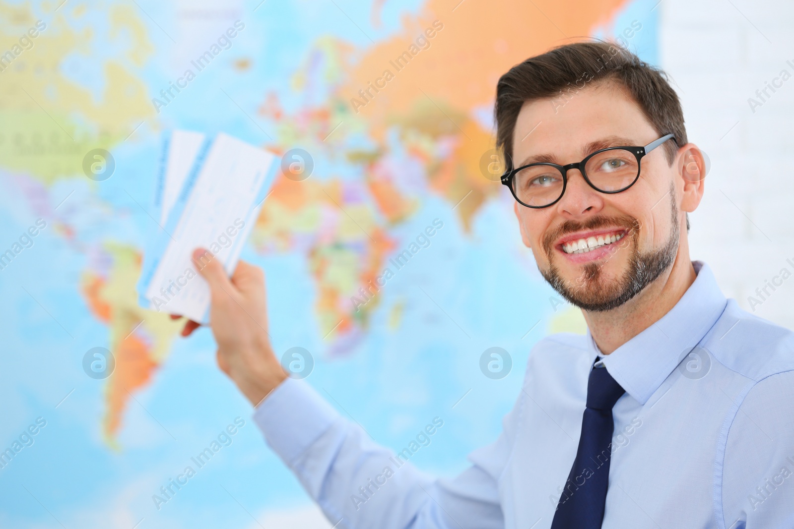 Photo of Male consultant holding tickets in travel agency. Space for text