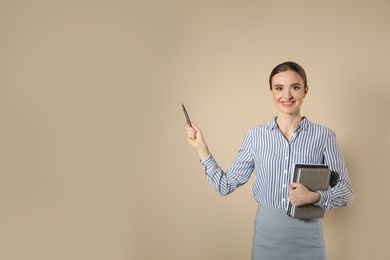 Portrait of young female teacher on beige background. Space for text