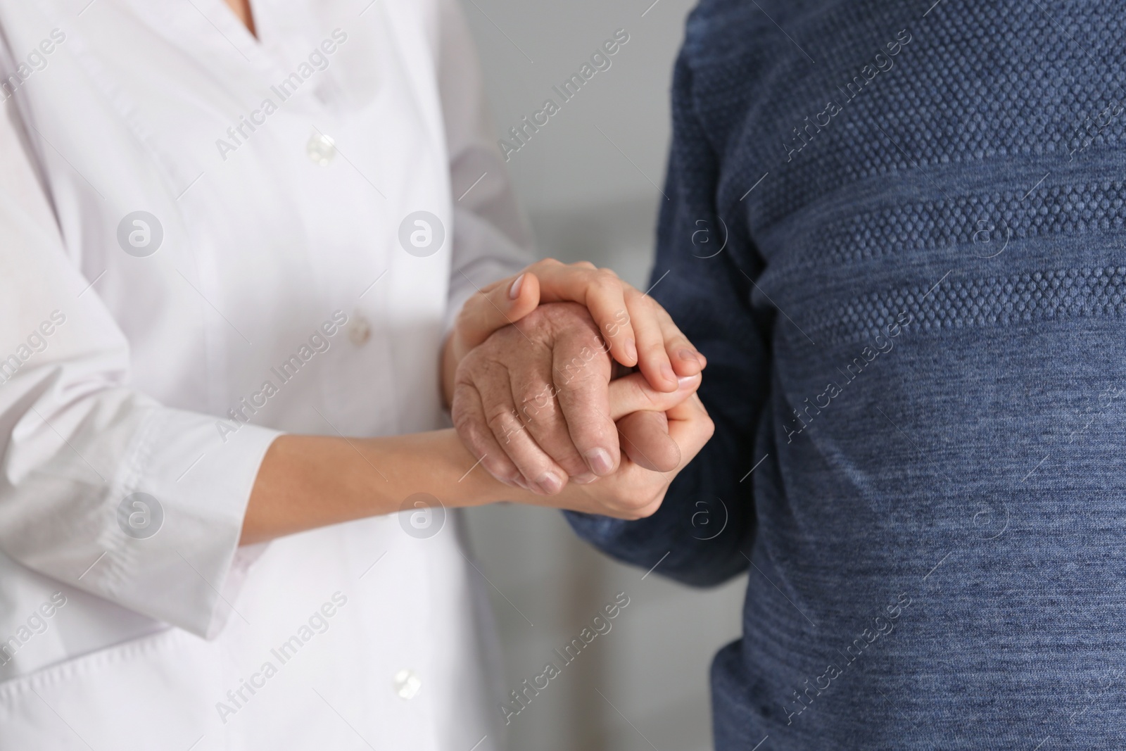 Photo of Elderly man with female caregiver on blurred background, closeup view