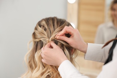 Photo of Hair styling. Professional hairdresser working with client in salon, closeup