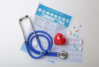 Composition with stethoscope and pills on white background. Cardiology service