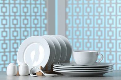 Photo of Set of clean dishware on light grey table