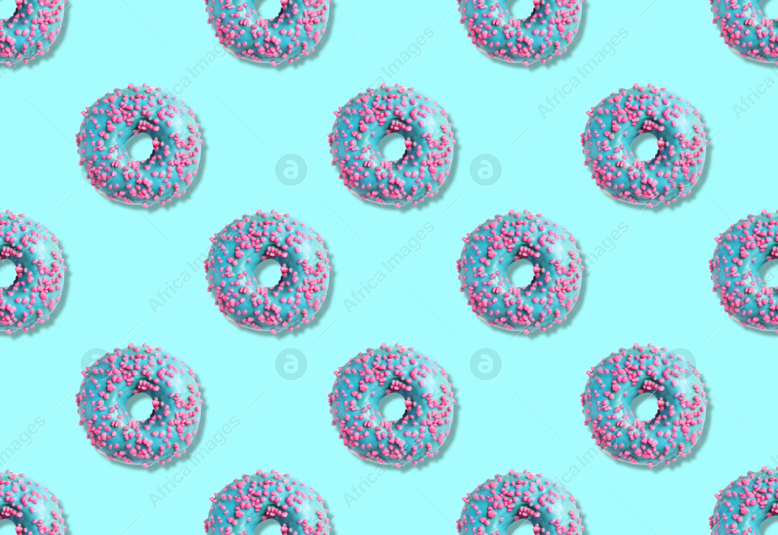 Image of Creative pattern design of glazed donuts on light blue background