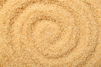 Granulated brown sugar as background, top view