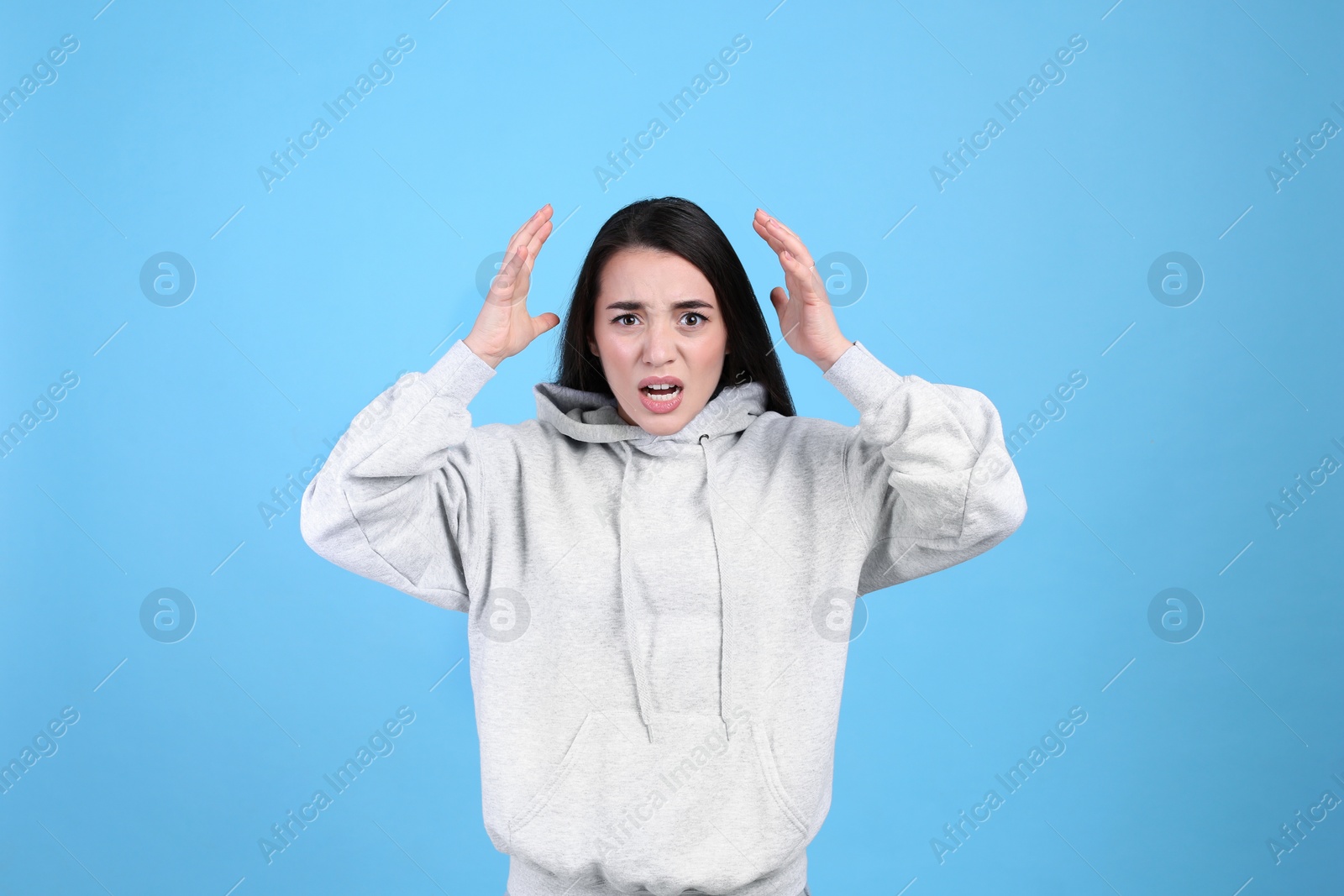 Photo of Portrait of stressed young woman on light blue background