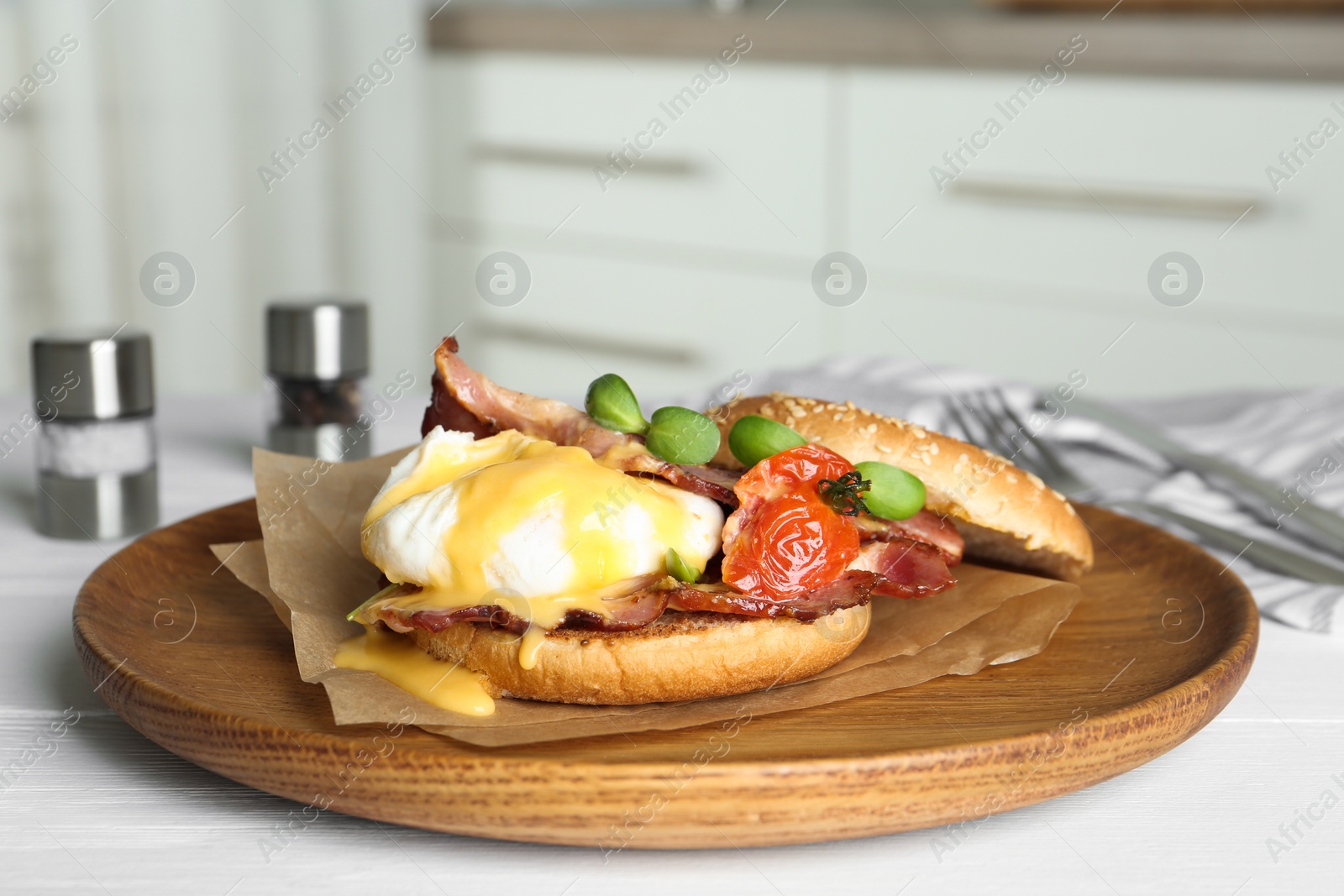 Photo of Delicious egg Benedict served on wooden plate