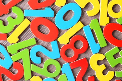 Photo of Colorful numbers on wooden school desk, top view