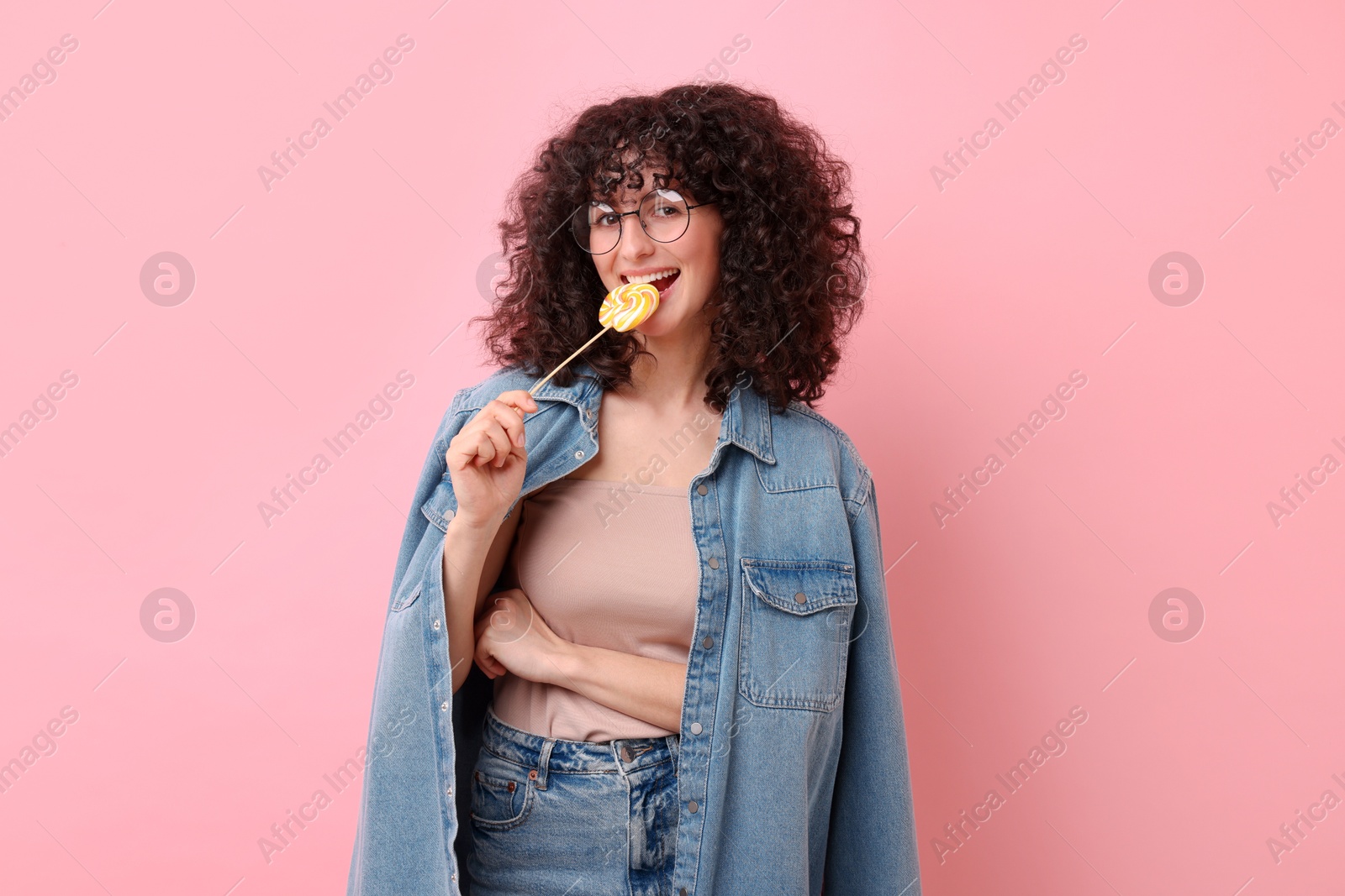 Photo of Beautiful woman with lollipop on pink background