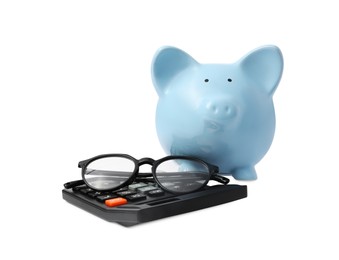 Calculator, glasses and piggy bank isolated on white