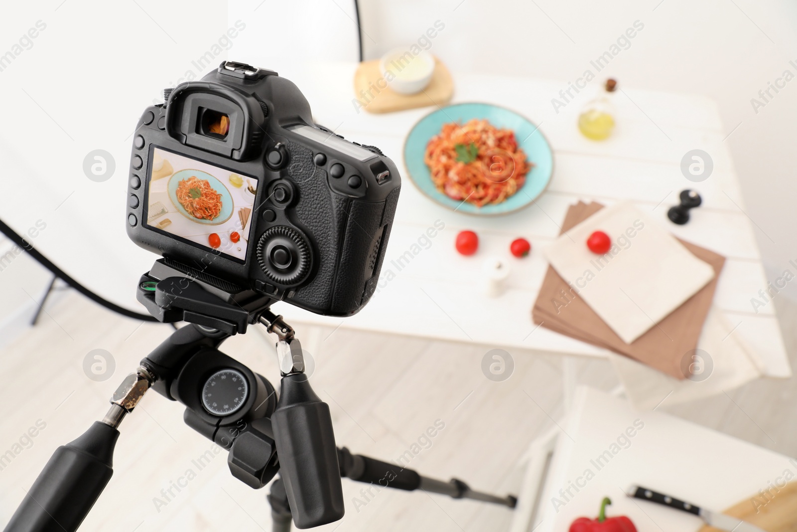 Photo of Professional camera with picture of spaghetti on display in studio, space for text. Food stylist