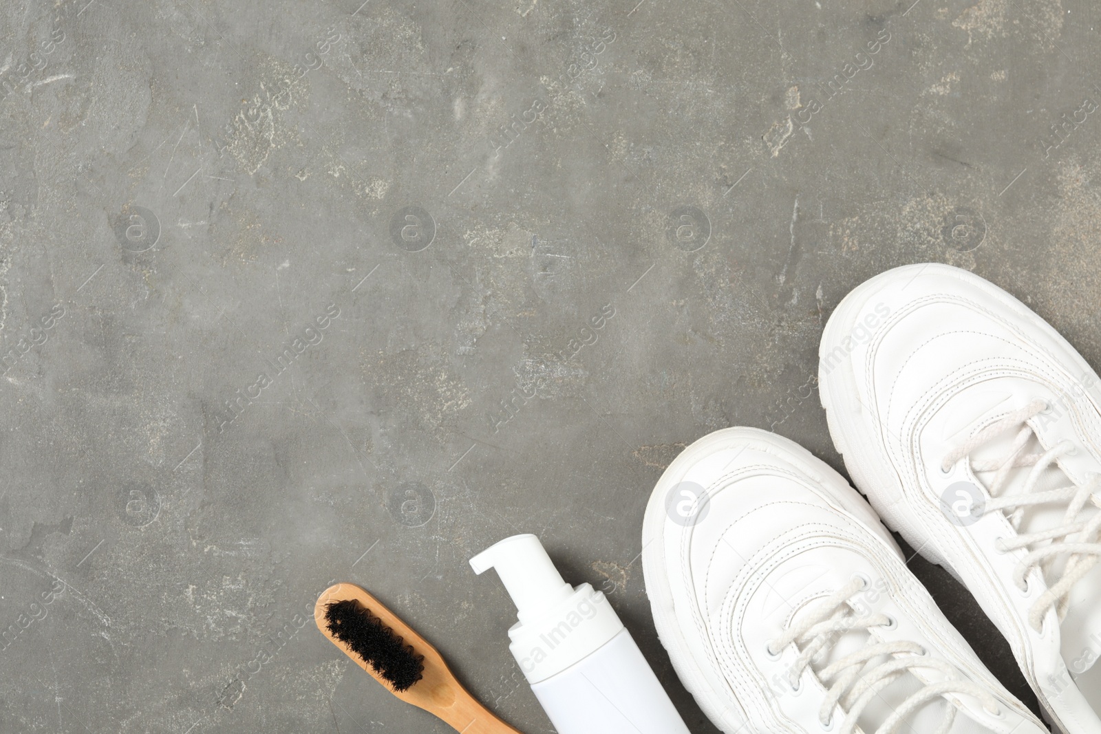 Photo of Flat lay composition with stylish footwear and shoe care accessories on grey background, space or text