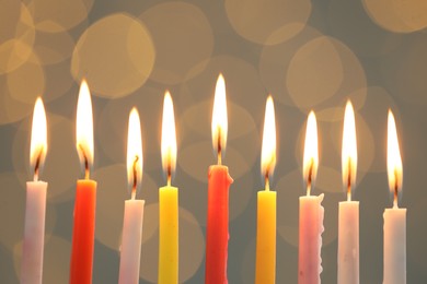 Photo of Hanukkah celebration. Burning candles against blurred lights, closeup