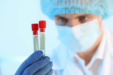 Photo of Scientist working with samples on light blue background, closeup. Medical research