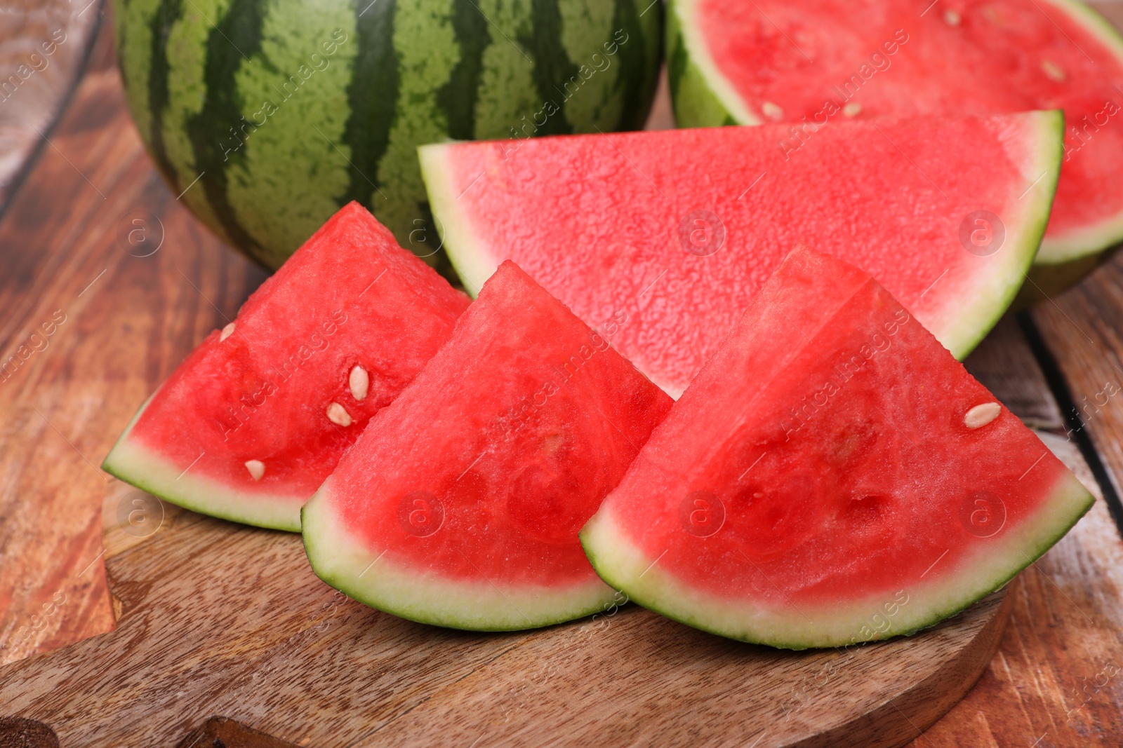 Photo of Pieces of juicy ripe watermelons on wooden table, closeup