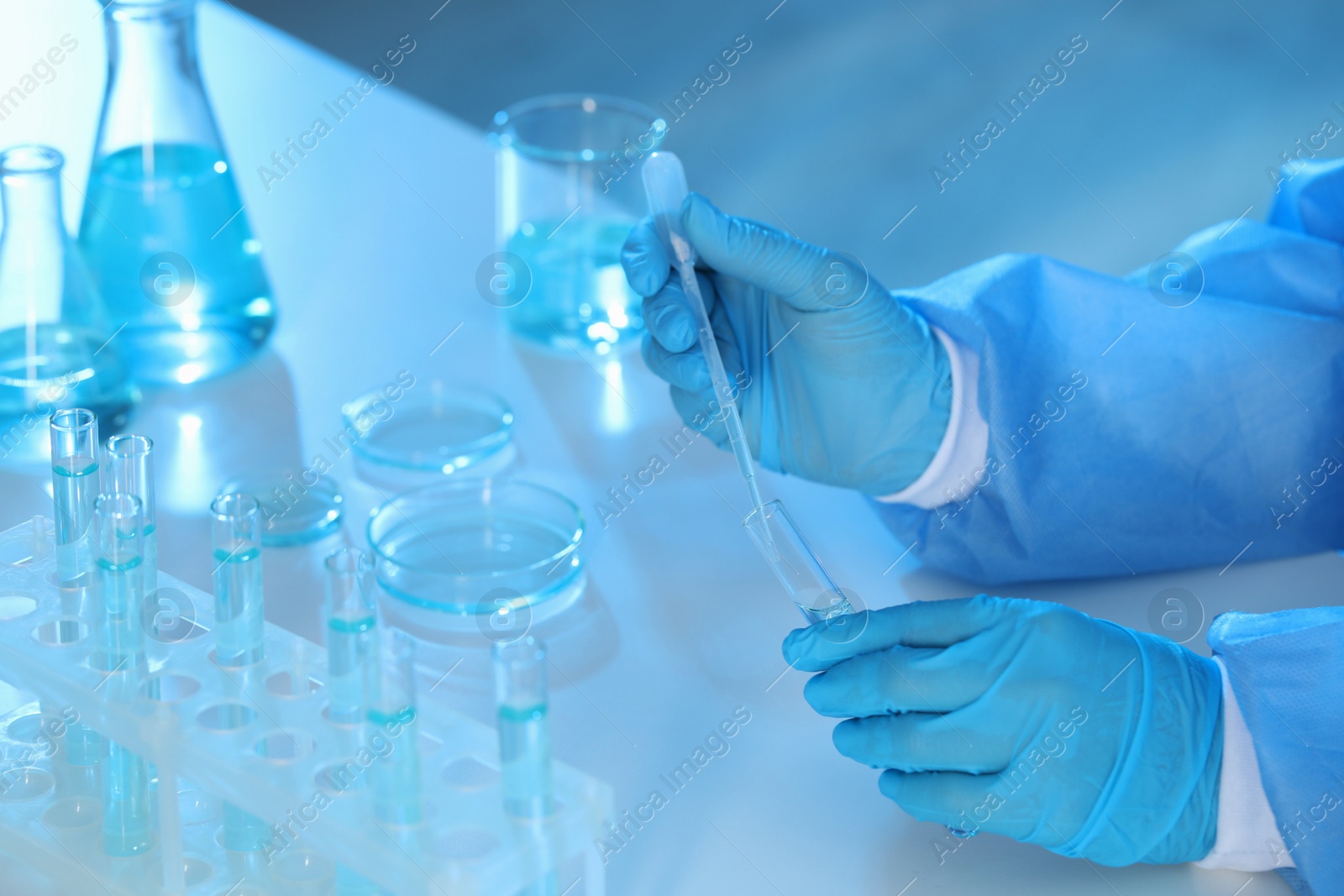 Photo of Scientist dripping sample into test tube at table, closeup. Medical research